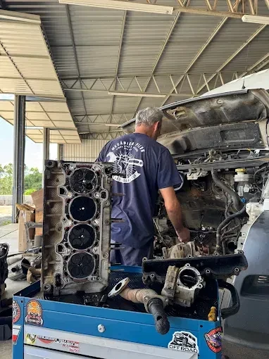 Mecânico trabalhando no motor de um veículo na oficina