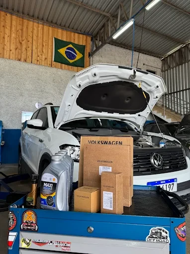 Volkswagen branco com o capô aberto em uma oficina